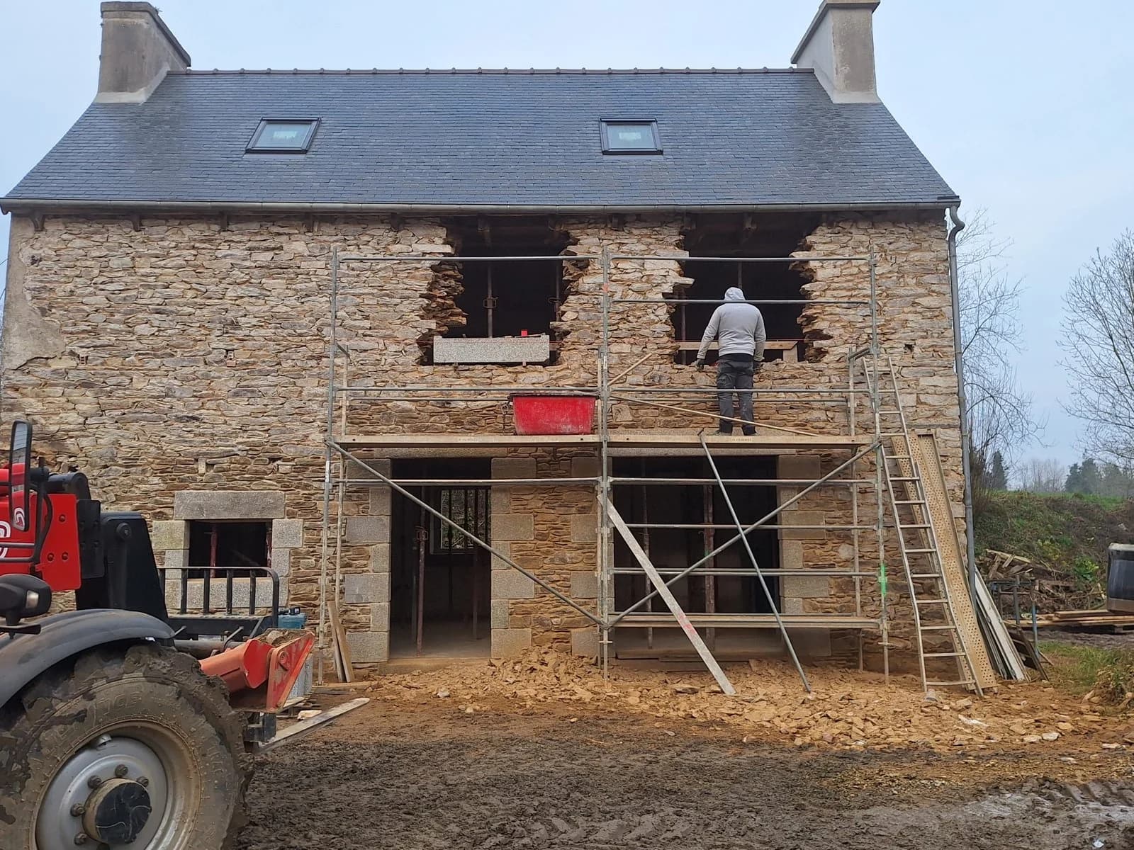 Chantier de rénovation d'une maison en pierre avec échafaudage