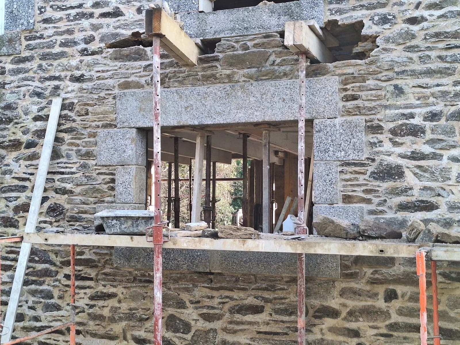 Ouverture créée dans un mur en pierre avec encadrement en granit