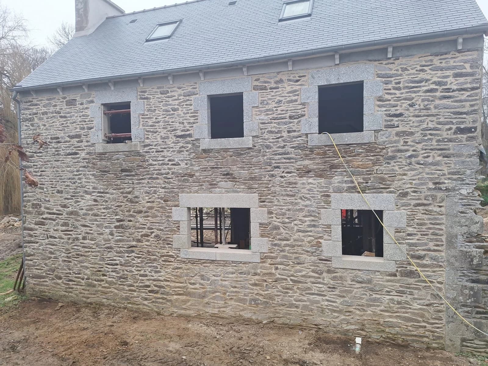 Façade en pierre rénovée avec encadrements en granit